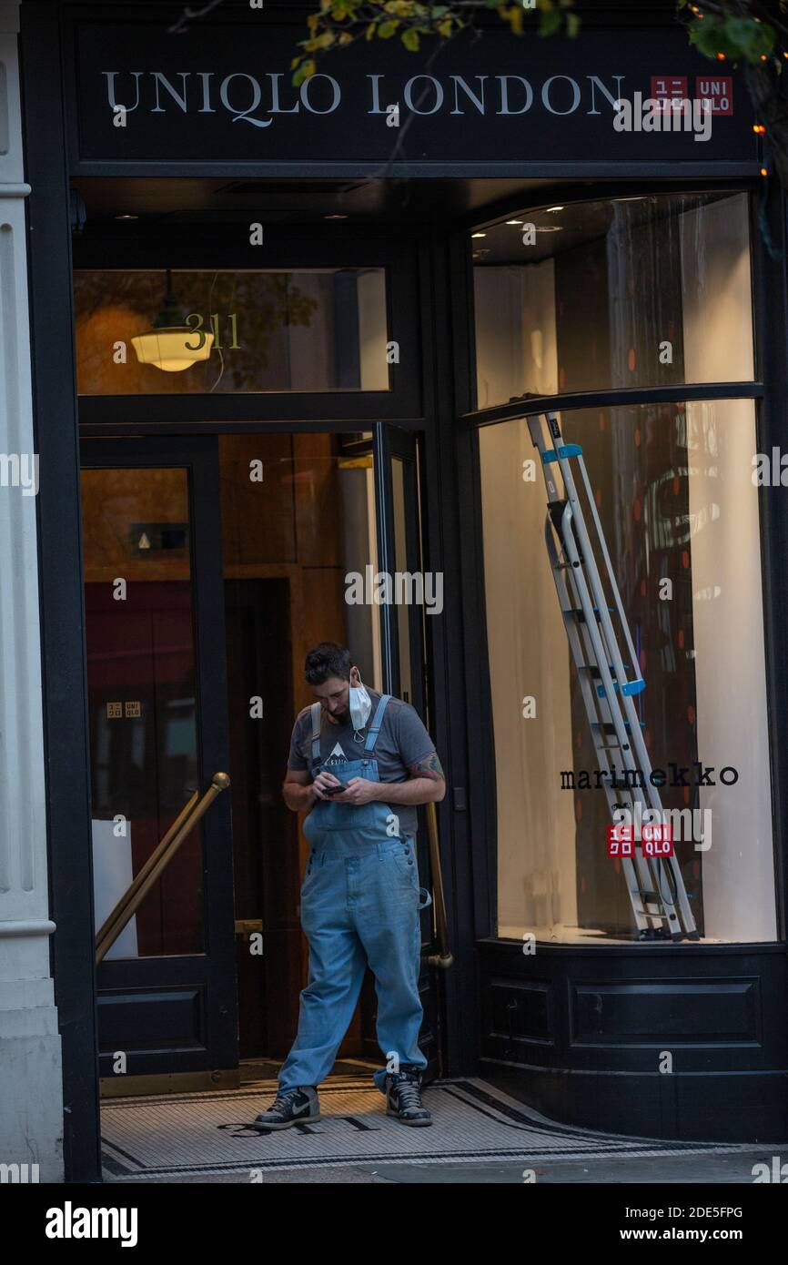 Tradesman stood in the doorway of a store being refurbished on Oxford Street during the final weekend of Coronavirus Lockdown#2, London, England, UK Stock Photo