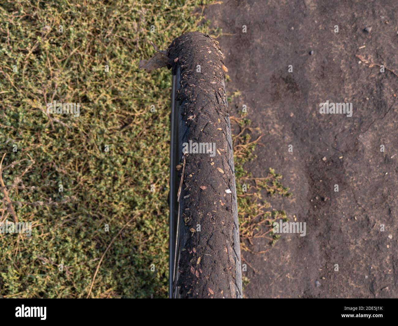 Top view on bicycle front wheel stuck with mud standing on the