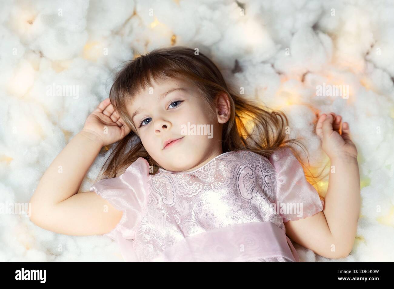 cute little girl lies in glowing clouds Stock Photo - Alamy