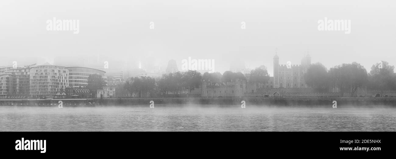 Black and white Tower of London on a misty atmospheric morning with fog and mist on the River Thames on Coronavirus Covid-19 lockdown day one in thick foggy weather, City of London, England, UK Stock Photo