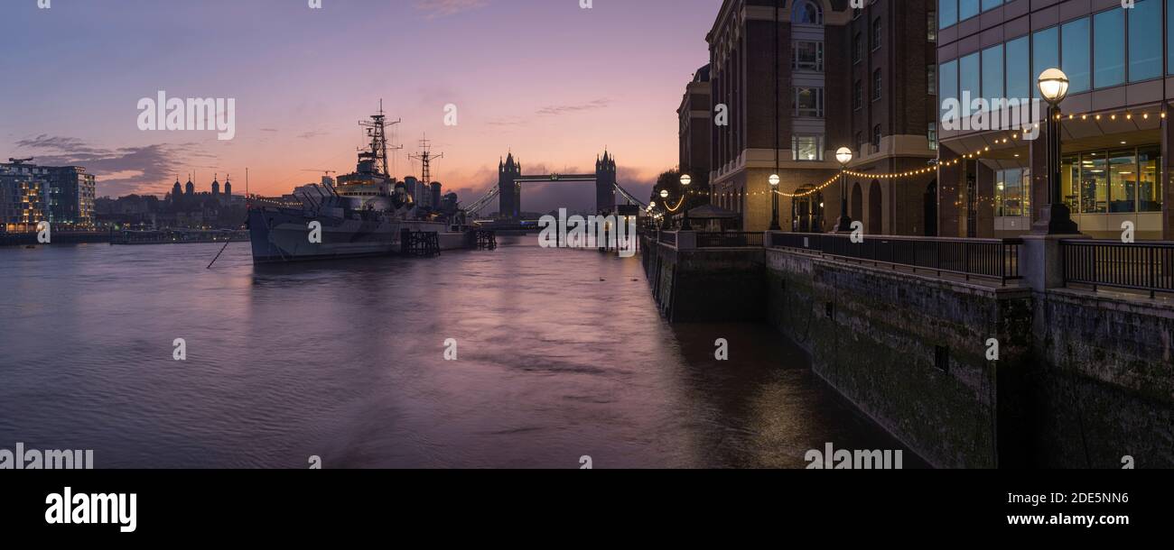 River Thames at sunrise with Tower Bridge and HMS Belfast ship, quiet empty and deserted at sunrise on day one of Coronavirus Covid-19 lockdown in England, UK Stock Photo