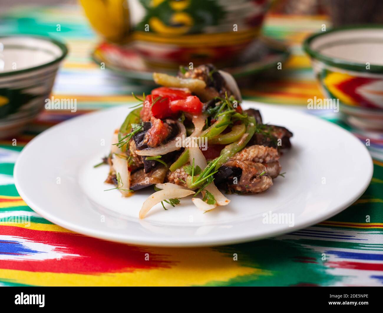 warm salad of green and red peppers, meat, eggplant, onions and tomatoes Asian style Stock Photo