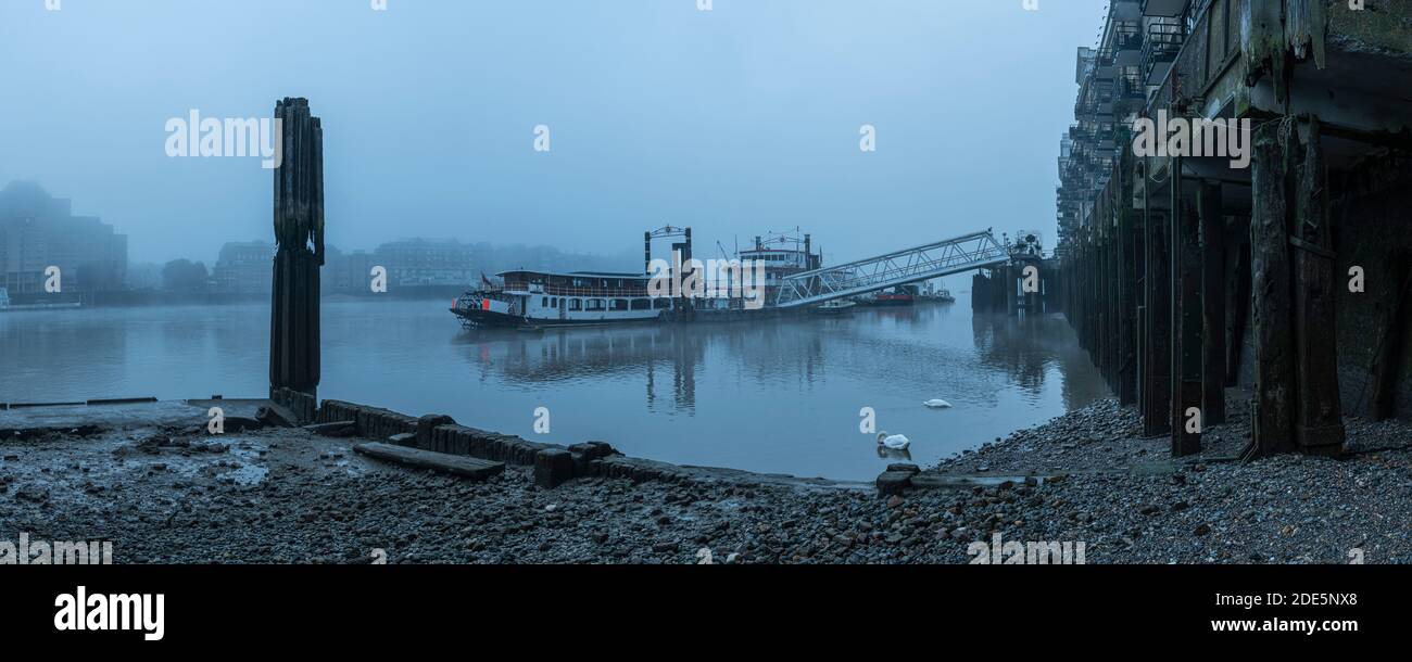 Butlers Wharf Pier and River Thames at low tide in thick fog and mist, in foggy and misty moody weather in London city centre during Covid-19 Coronavirus lockdown, England, UK Stock Photo