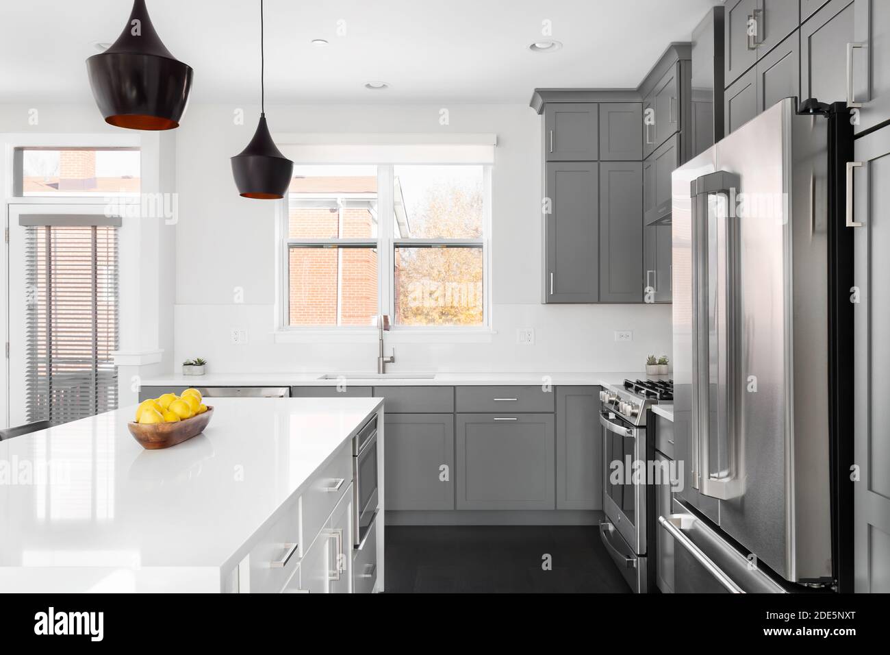 A Modern Kitchen With Grey Cabinets A Bowl Of Lemons On The White Granite Counter Tops And Dark Hardwood Floors Stock Photo Alamy