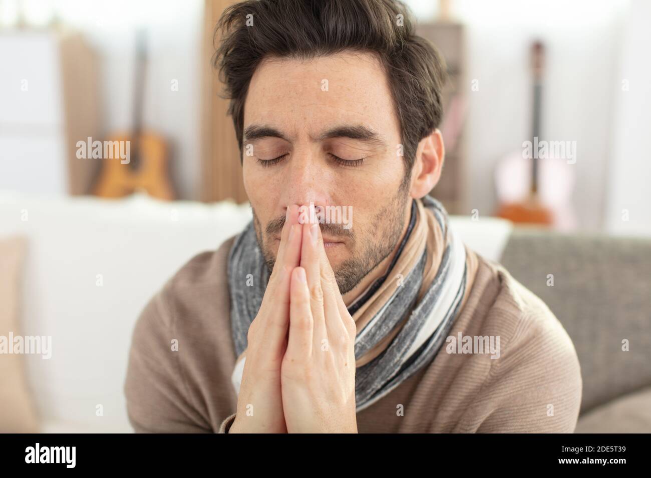 handsome man praying at home Stock Photo