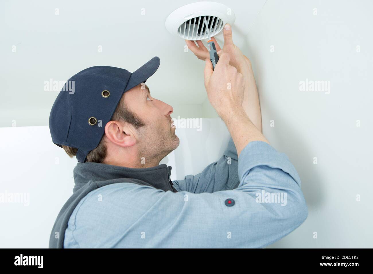 handyman installing ceiling vent Stock Photo Alamy