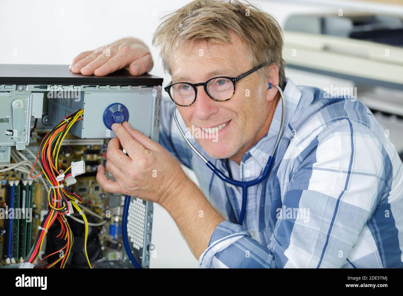 mature engineer repairs computers hard drive Stock Photo