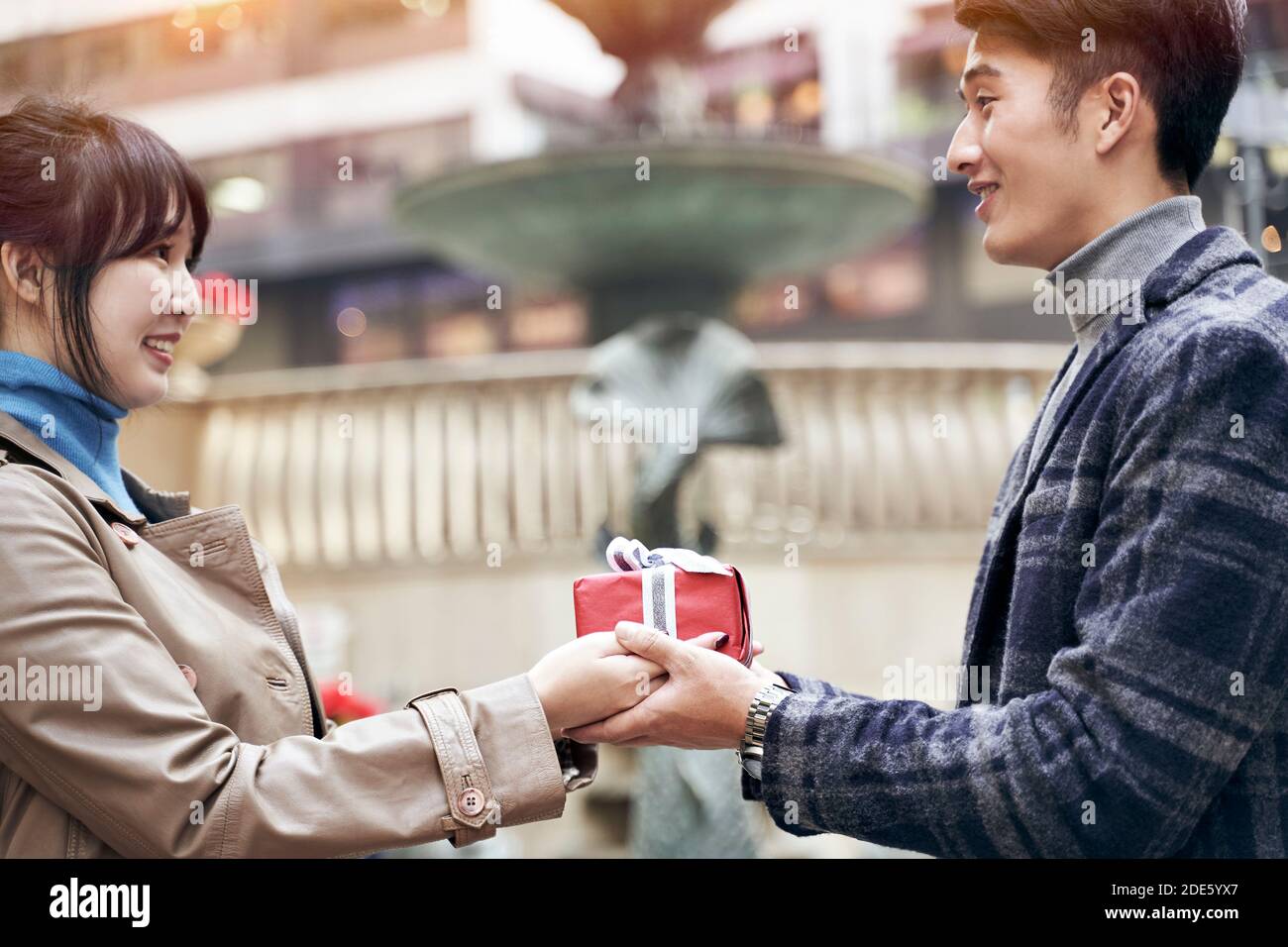 young asian woman ceceiving a christmas or birthday present from husband or boyfriend Stock Photo