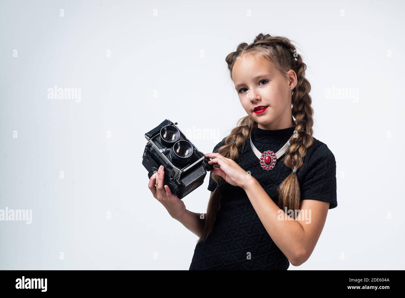 teen girl making photo. retro camera. happy childhood. kid has elegant  look. photography in modern life. child with old fashioned photo camera  isolated on white. vintage technology. copy space Stock Photo -