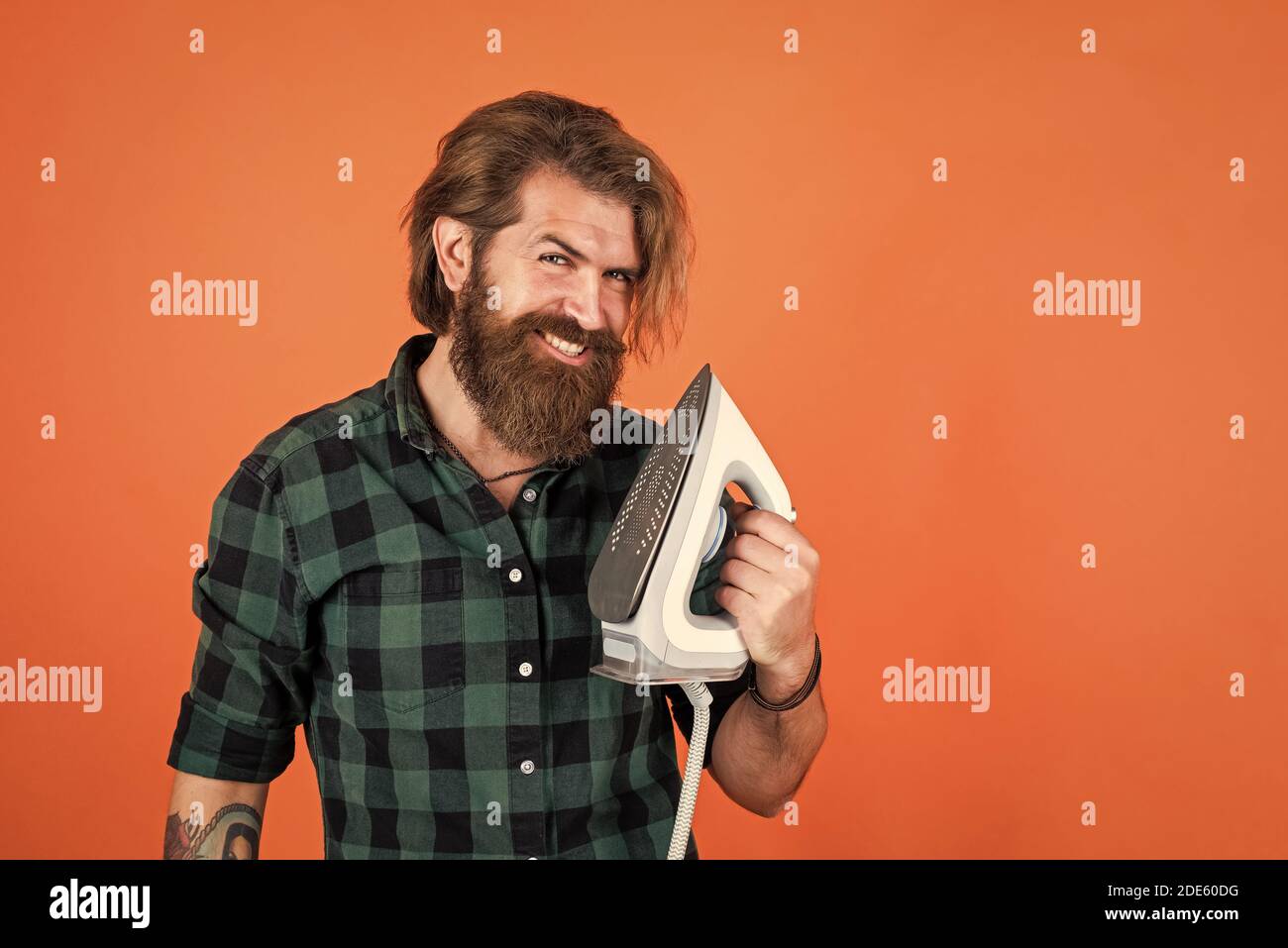 the smart choice. mature young man husband doing clothing ironing at