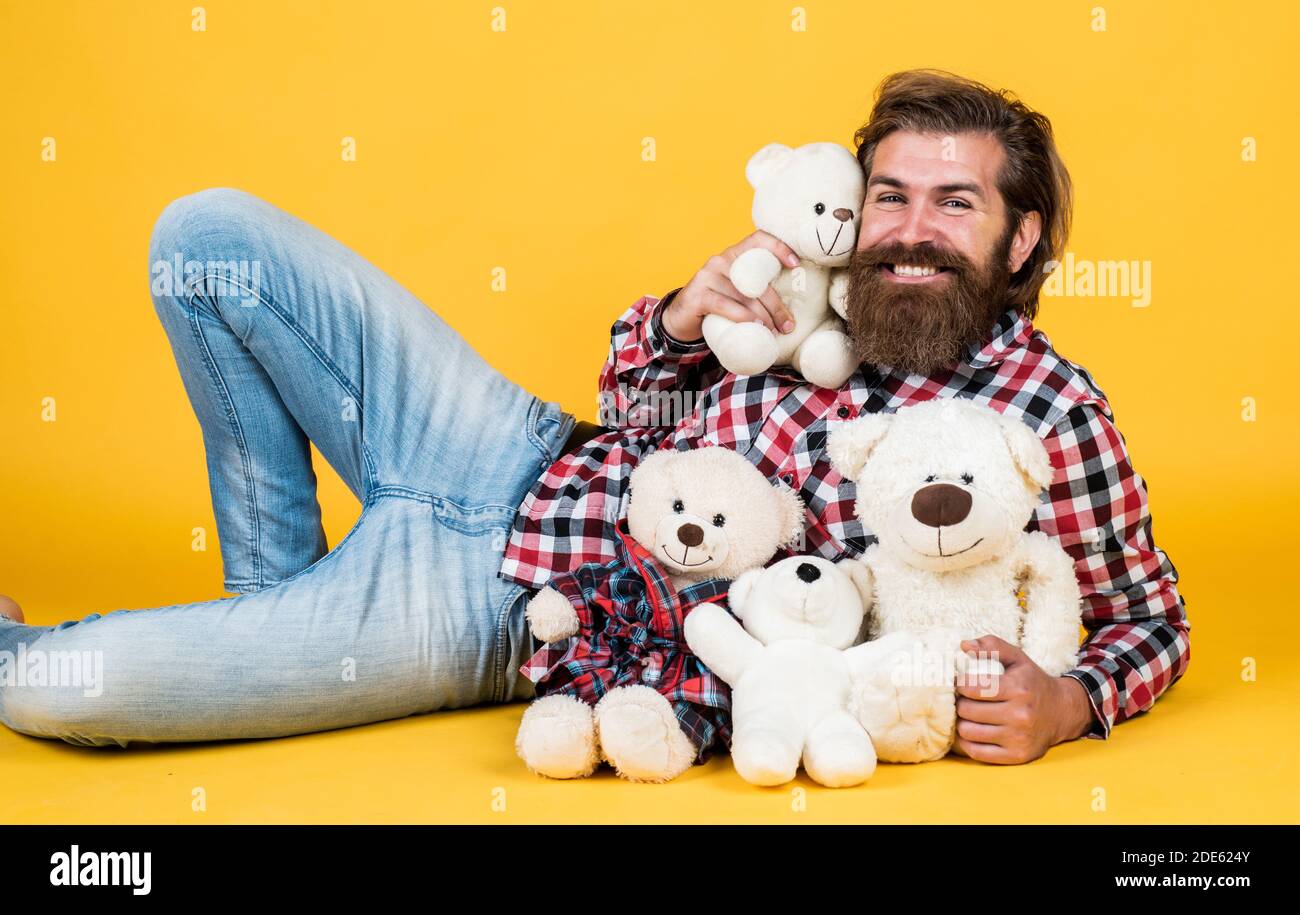 Caucasian mature hipster with trendy hairstyle in checkered shirt hold teddy bear toy, sale. Stock Photo