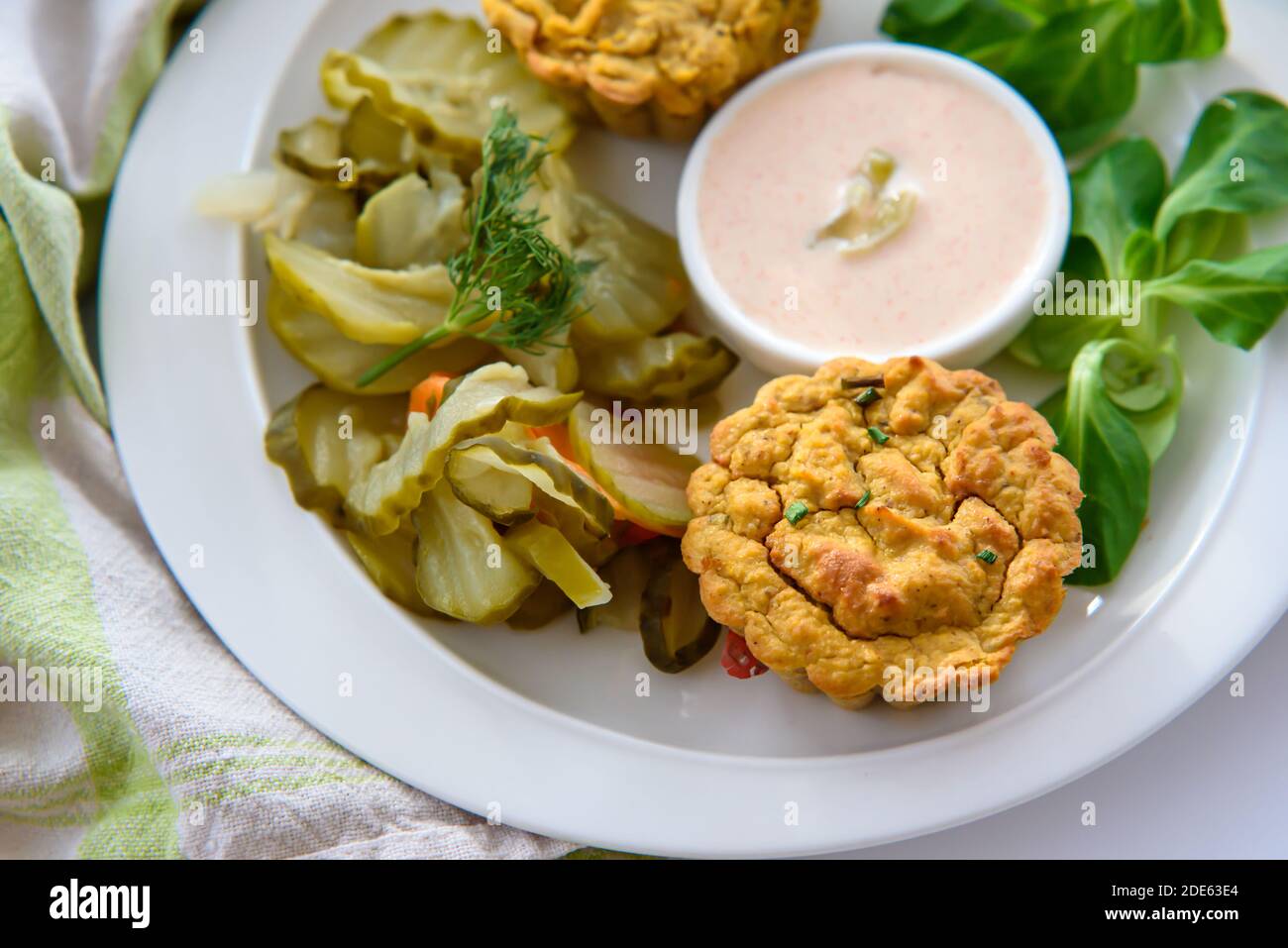 Healthy breakfast- vegan vegetable muffins with light chili-mayo dip and cucumber pickle  salad, close-up in the beautiful natural morning light Stock Photo