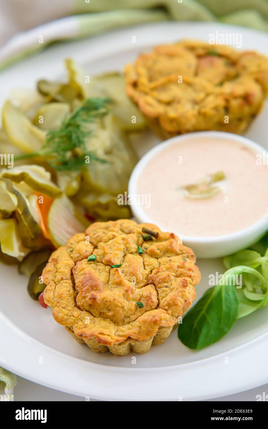 Vegan vegetable muffins with light chili-mayo dip and cucumber pickle salad, close-up on a muffin Stock Photo