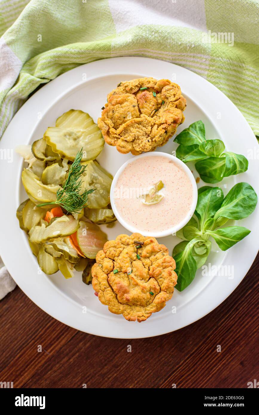 Flat lay of a vegan vegetable muffins with light chili-mayo dip and cucumber pickle salad, natural light Stock Photo