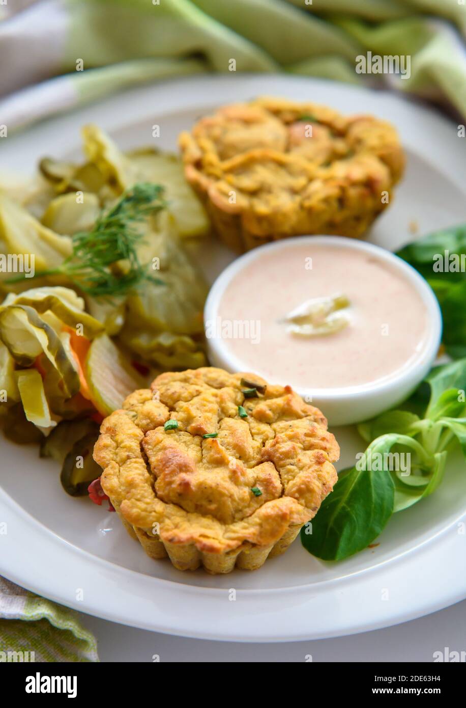 Healthy breakfast- vegetable muffins with light chili-mayo dip and cucumber pickle salad, close-up, early morning light Stock Photo