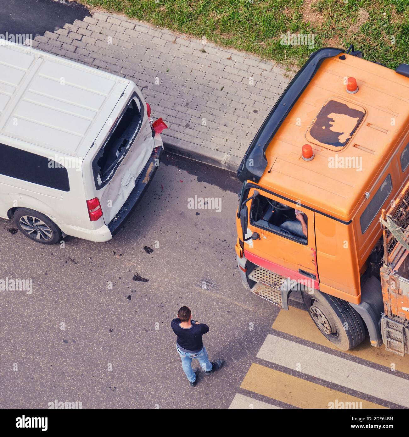 Accident on the road, a truck crashed into a minibus, drivers are standing at the car at the pedestrian crossing Stock Photo