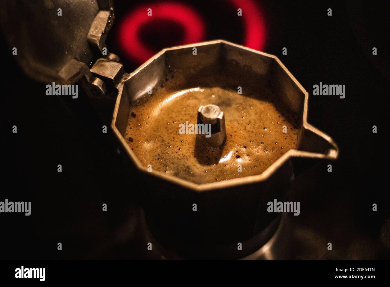 Making hot coffee in moka coffee maker on stove from boiling water