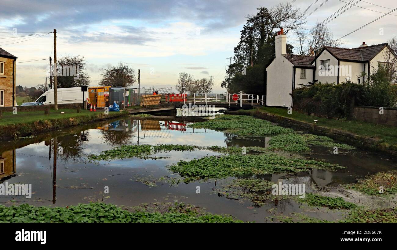 This canal swing bridge is being electrified as a safety improvement while the floating weed builds up against a pontoon installed across the canal Stock Photo