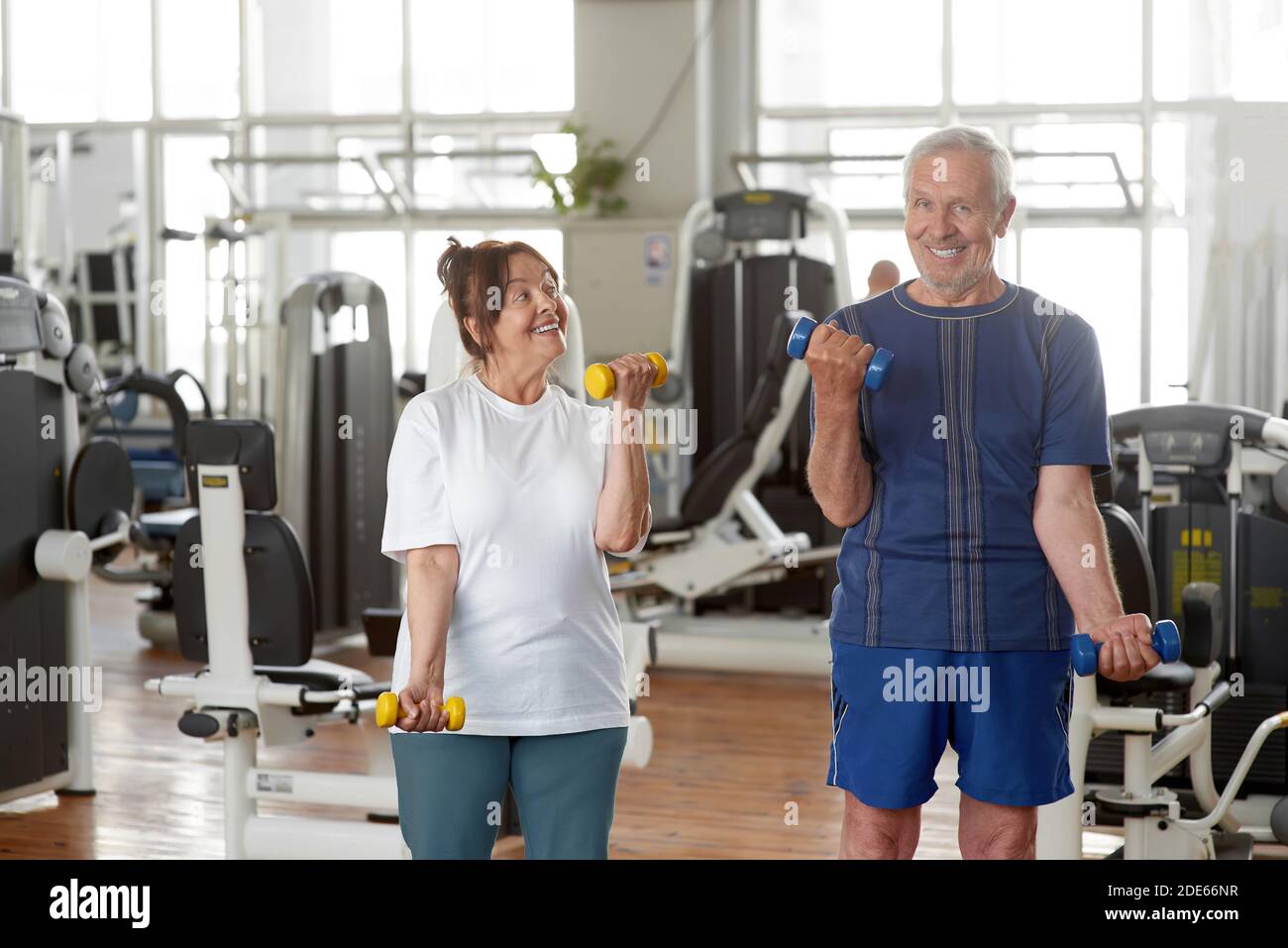 Senior caucasian couple exercising using dumbbells. Stock Photo