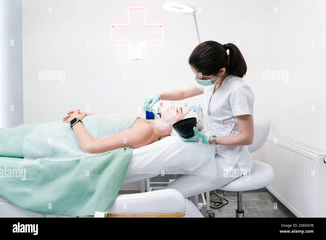 The young female client of cosmetic salon having a face cleaning procedure. The doctor cosmetologist cleaning skin. Concepts of skin care and beauty s Stock Photo