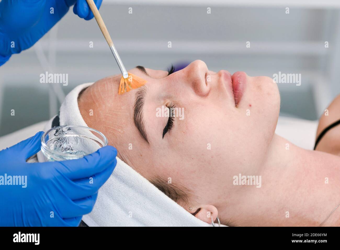 The young female client of cosmetic salon having a face cleaning procedure. The doctor cosmetologist cleaning skin. Concepts of skin care and beauty s Stock Photo