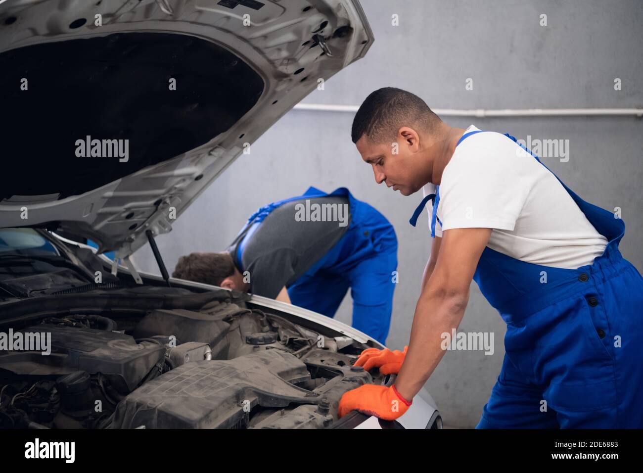 Two experienced techies repair a broken car engine Stock Photo - Alamy