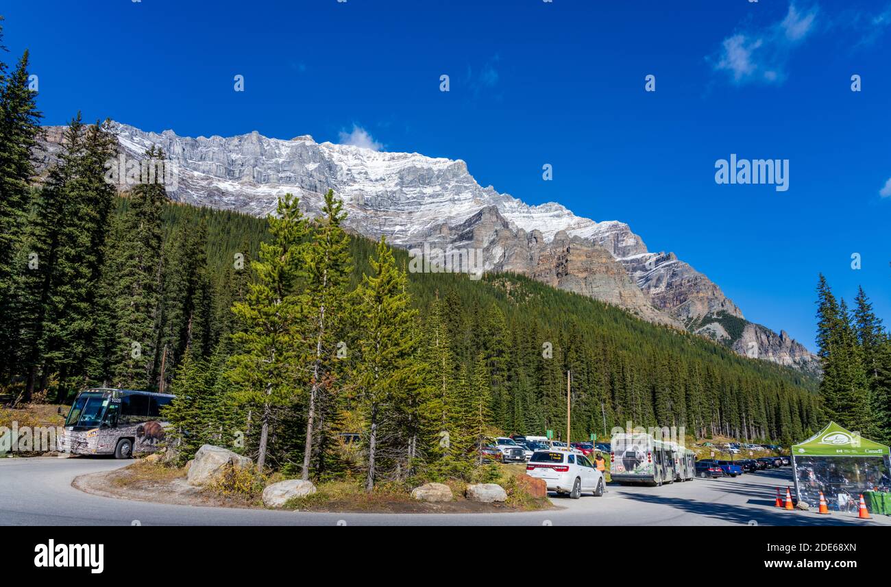Moraine Lake Car Parking Area in summer sunny day. Bus and cars stop