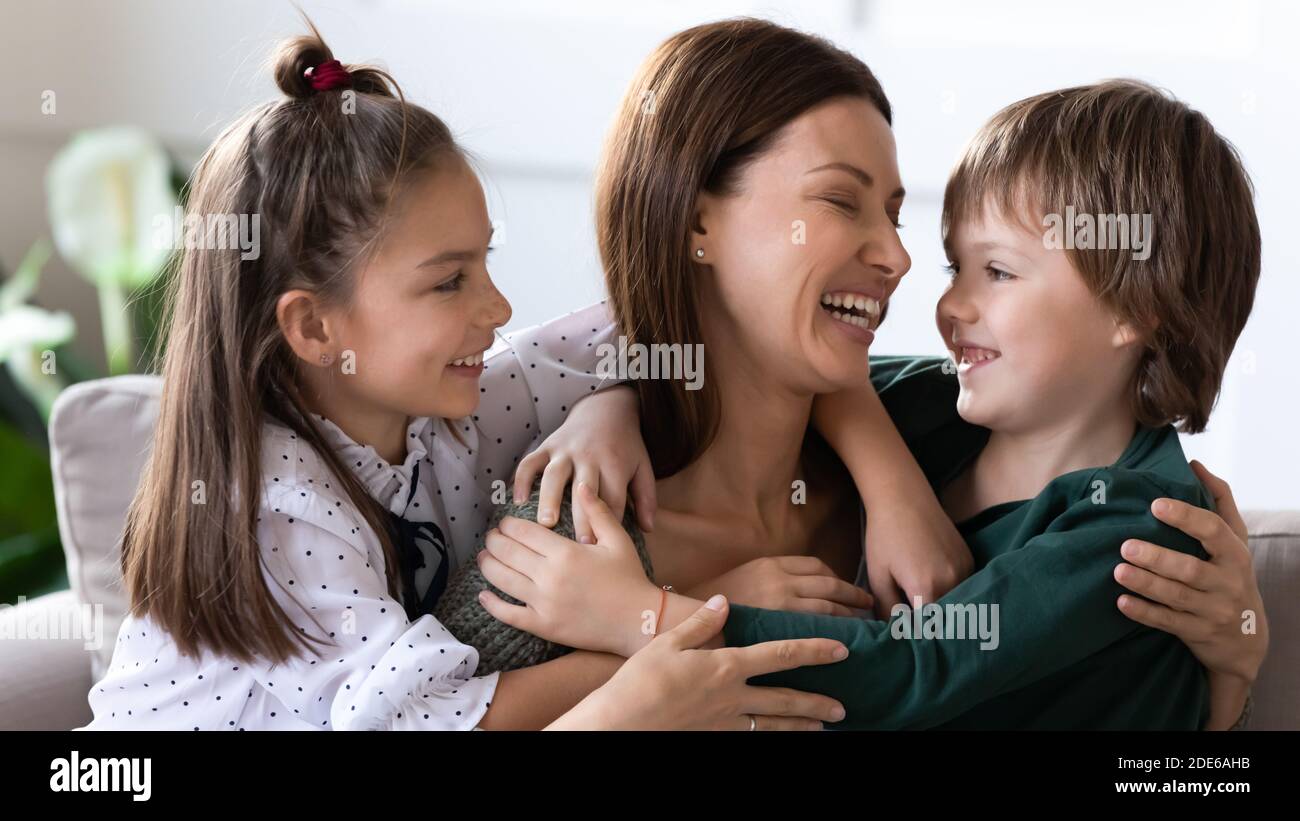 Two children hug embrace happy mom showing love Stock Photo