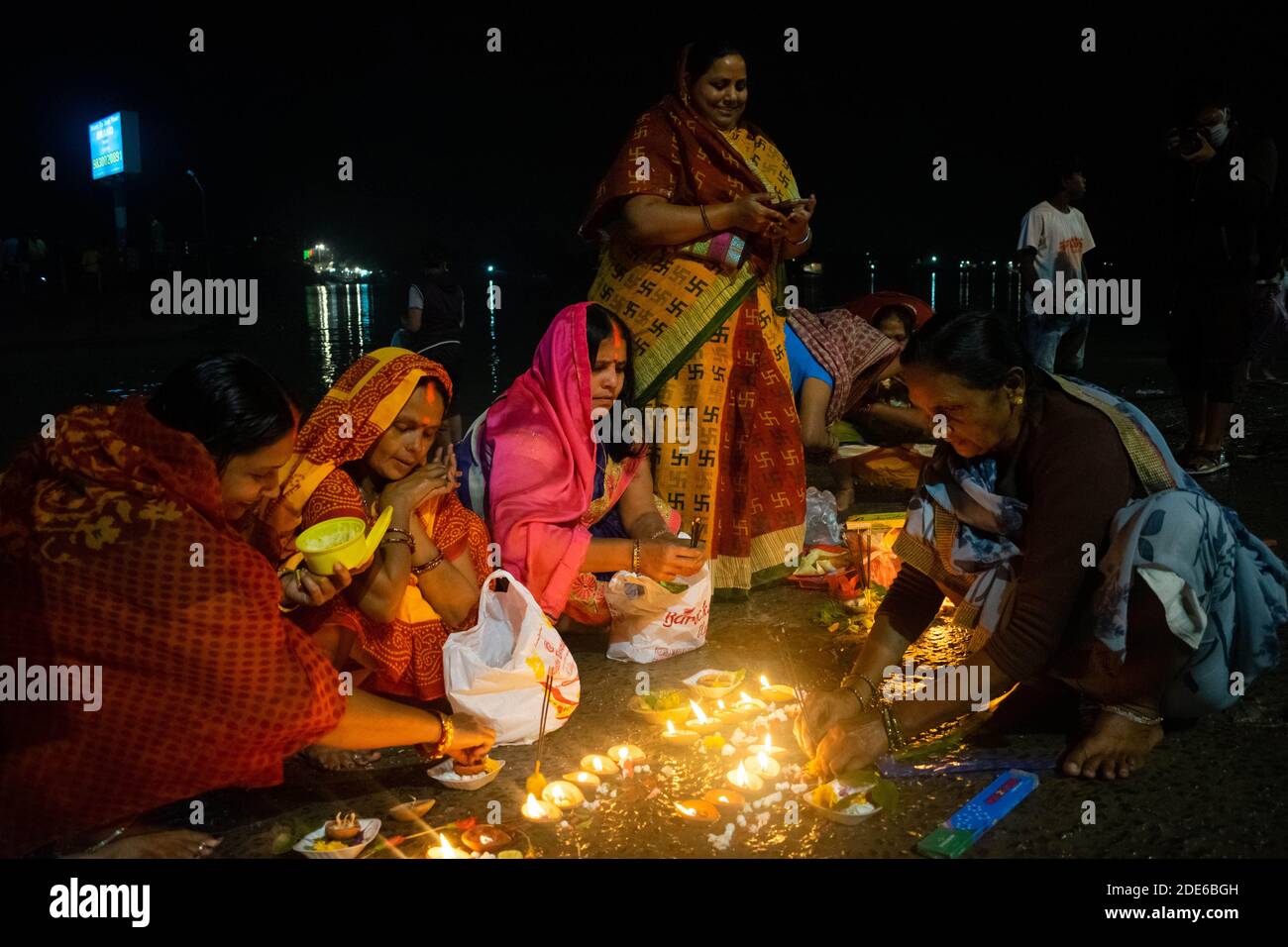 Barrackpore, West Bengal, India. 29th Nov, 2020. Women are lightening up earthen lamps for the rituals of Dev Deepawali at the bank of the holy river Ganga. Because of COVID19 pandemic situation, very few people have come to celebrate this festival at the bank of river Ganga this year because the government has banned all kinds of gatherings. Credit: Santarpan Roy/ZUMA Wire/Alamy Live News Stock Photo
