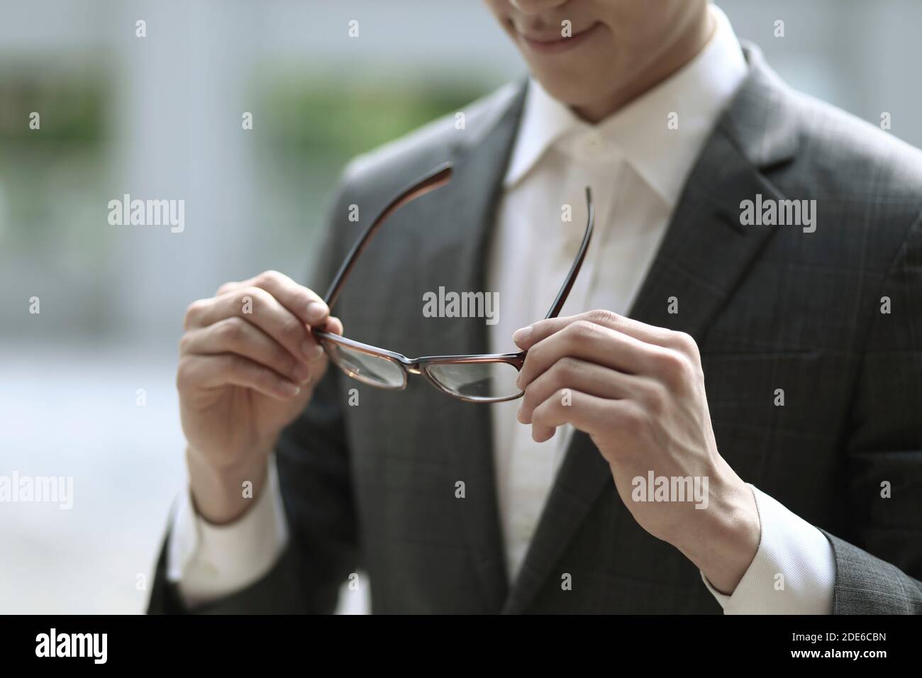 Close up of businessman holding eyeglasses Stock Photo