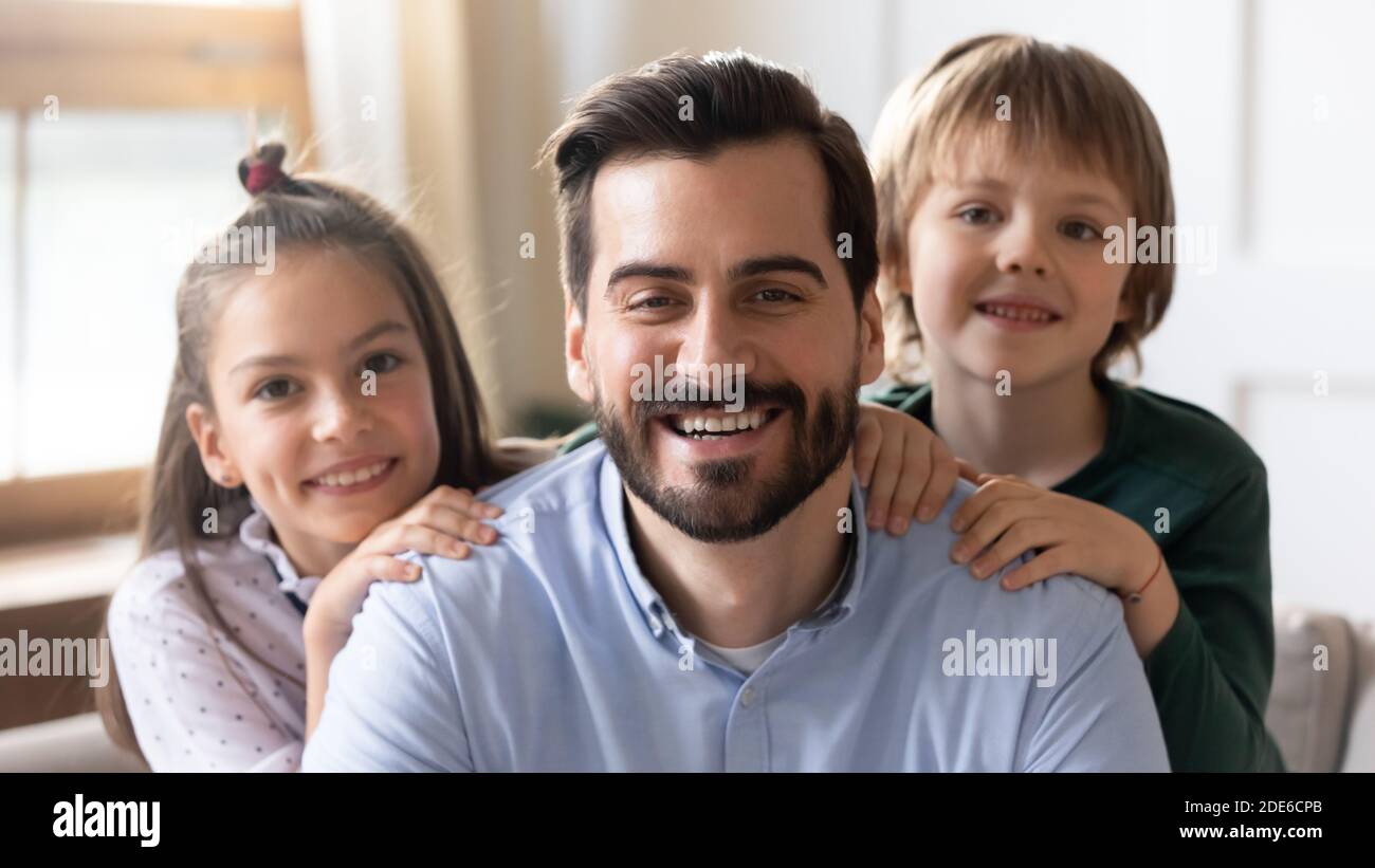 Portrait of smiling young dad posing with two kids Stock Photo