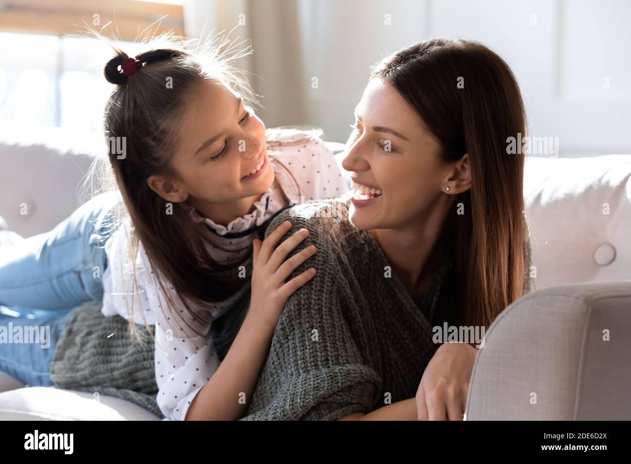 Happy young mom and little daughter relax on couch Stock Photo - Alamy