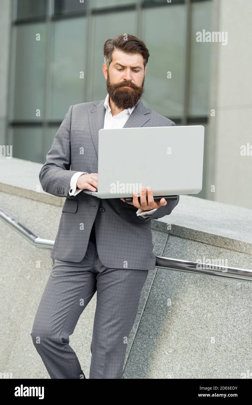 Computer communication network. Bearded man use computer outdoors. Business communication. Making video call. E-mail mail and messaging. Internet surfing. 3G. 4G. Modern technology. Stock Photo