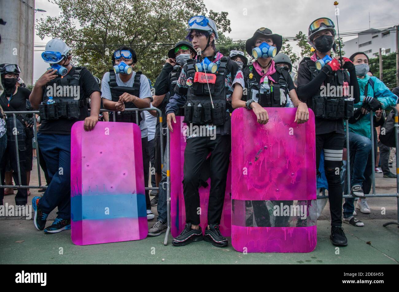 The volunteer guard stand on guard with handmade shields during the demonstration. Thousands of pro-democracy protesters gathered at BTS wat phra si mahathat where they marched to the 11th Infantry Regiment (King's guard) to oppose the legislation to control over some army units by King Maha Vajiralongkorn and call for monarchy reforms. Stock Photo