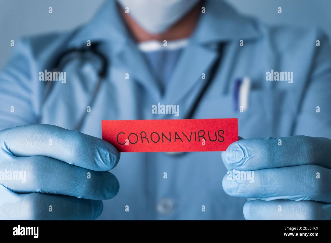 Concept of Covid-19 pandemic.Doctor holding a red paper that written coronavirus. Stock Photo