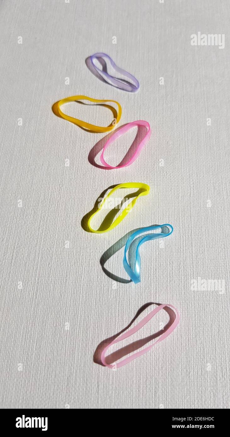 Set of small elastic bands for hair on a white table. Stock Photo