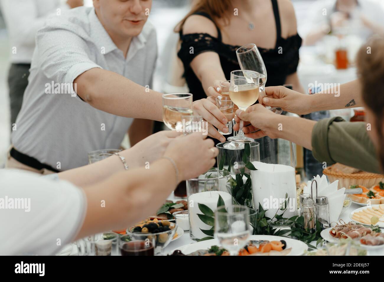 Faceless people clinking the champagne glasses at the wedding. Party in the restaurant Stock Photo