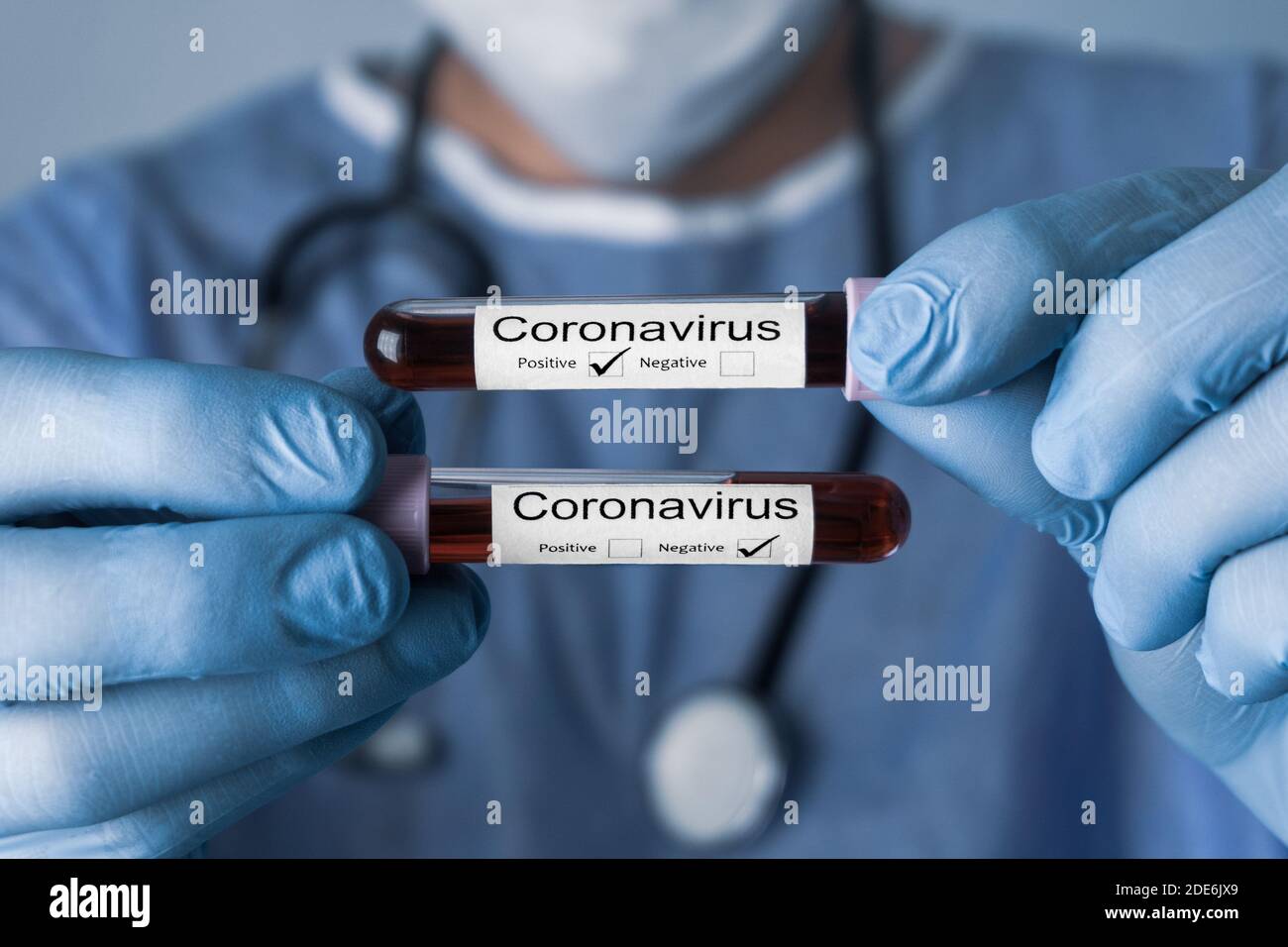 Doctor holding test tubes with Positive and Negative Coronavirus test blood samples. Covid 19 concept and background. Stock Photo
