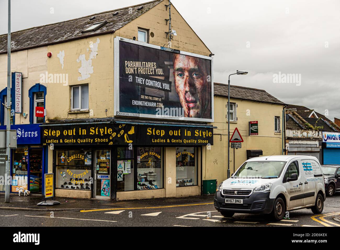 A billboard on Canmore Street, Belfast, Northern Ireland, warns against paramilitary control with the portrait of a young man and the words "Paramilitaries don't protect you. They control you.", referring viewers to "Ending the Harm", a Northern Ireland Department of Justice campaign against illegal money lending and paramilitary intimidation. Stock Photo