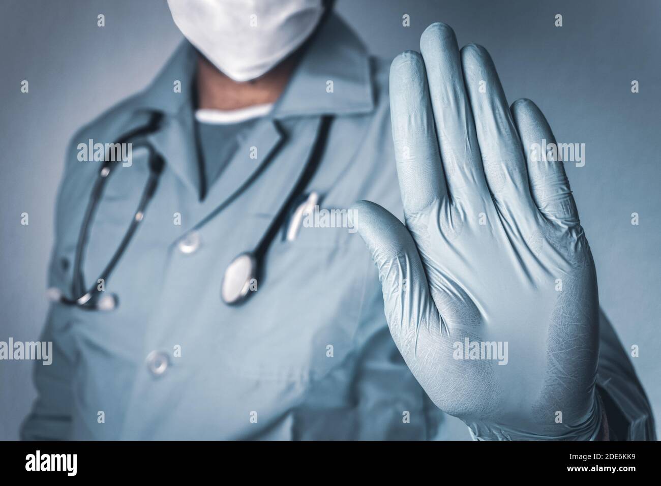 Hand stop sign. Doctor wearing medical mask and gloves. Coronavirus, Covid-19 concept and background. Stock Photo