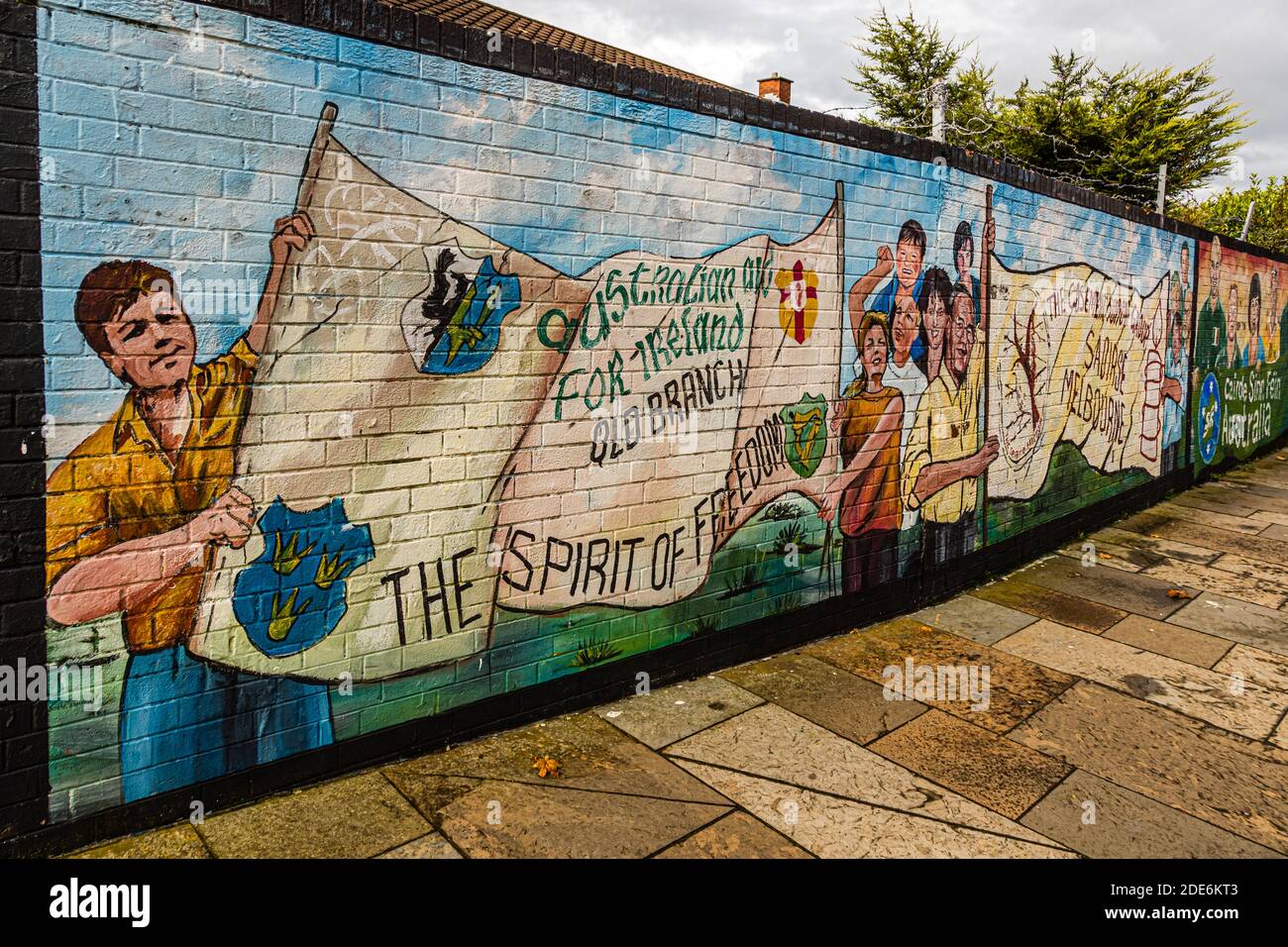 The mural "Cairde Sinn Féin Australia" on Conway Street, Belfast, Northern Ireland, shows children and adults holding banners inscribed "Australian Aid for Ireland – Old Branch" and the slogan "The Spirit of Freedom". Stock Photo