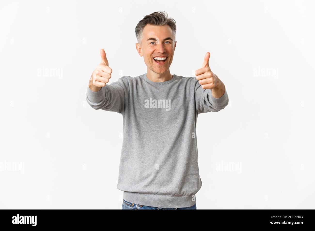 Portrait of cheerful middle-aged man praising good work, standing over ...