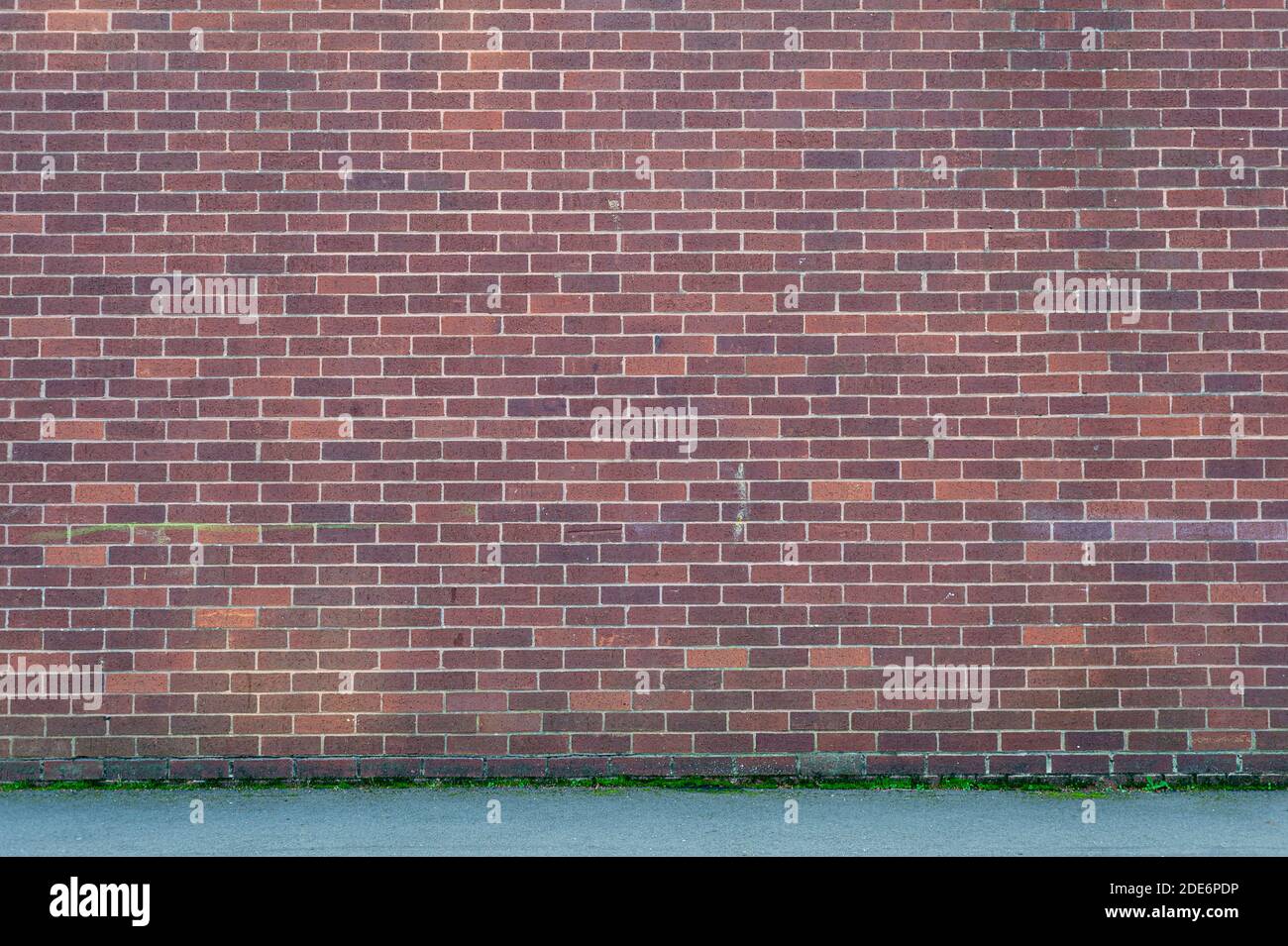 Brickwall background with sidewalk Stock Photo