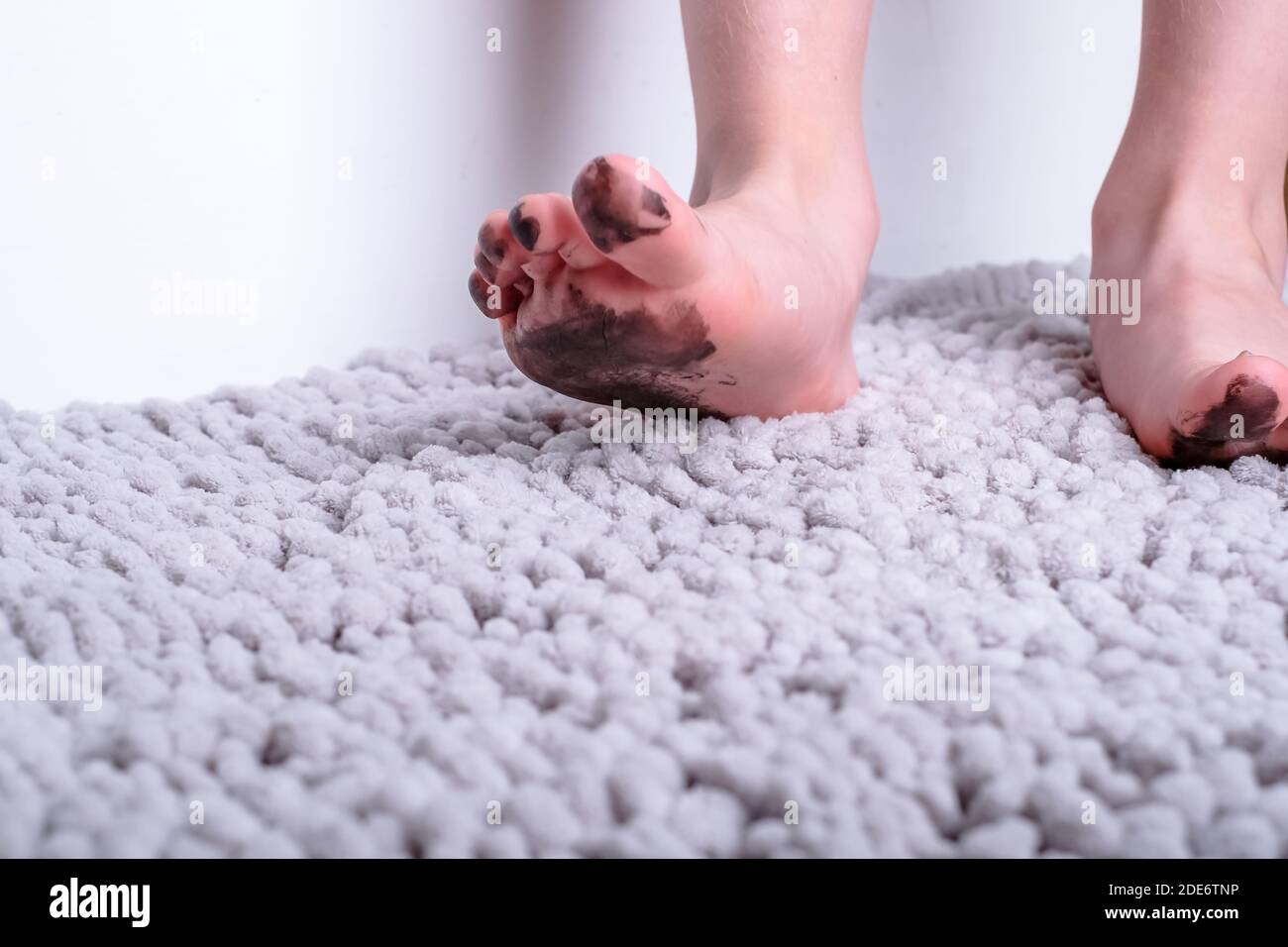 Close up of dirty barefoot of child on mat. place for text. daily life dirty stain for wash and clean concept Stock Photo