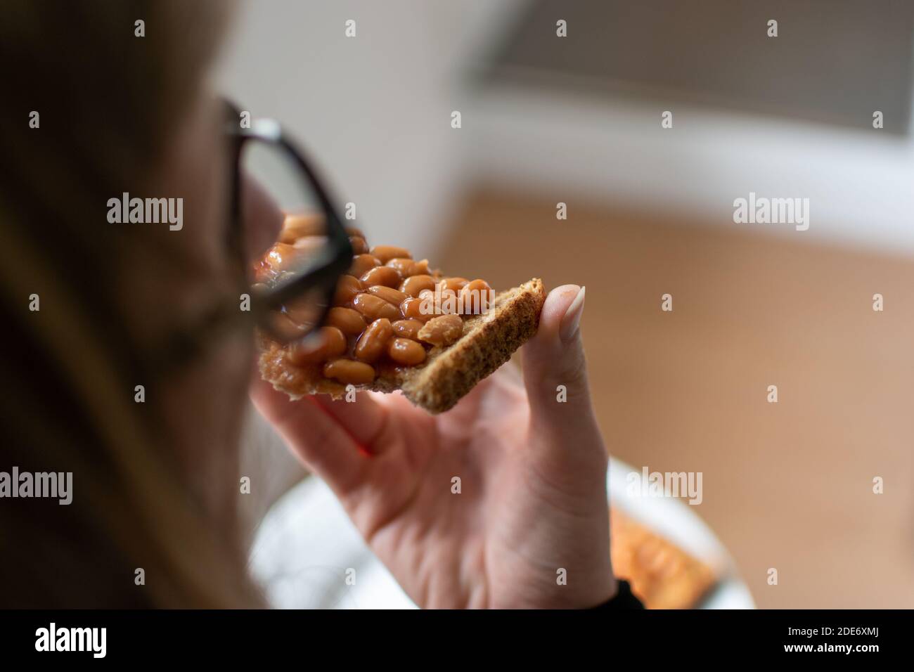 A woman eating baked beans on toast Stock Photo Alamy