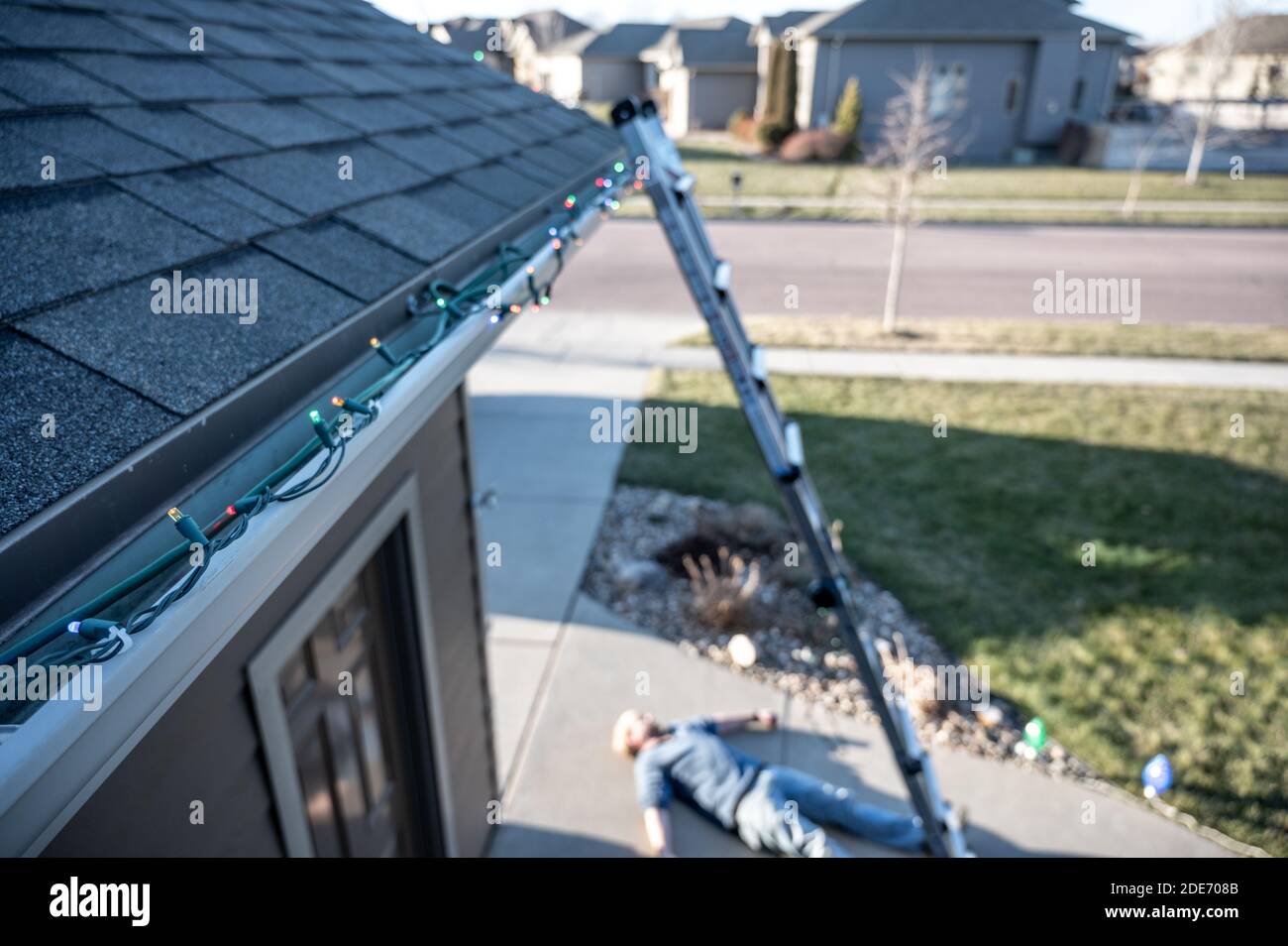 Concept of falling danger involved with hanging Christmas lights on the