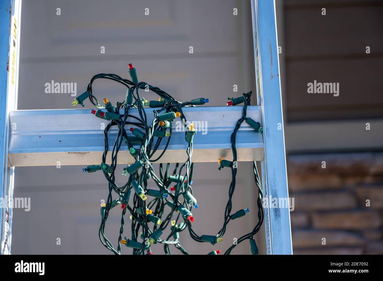 Prep for installing Christmas lights by leaning a ladder against a
