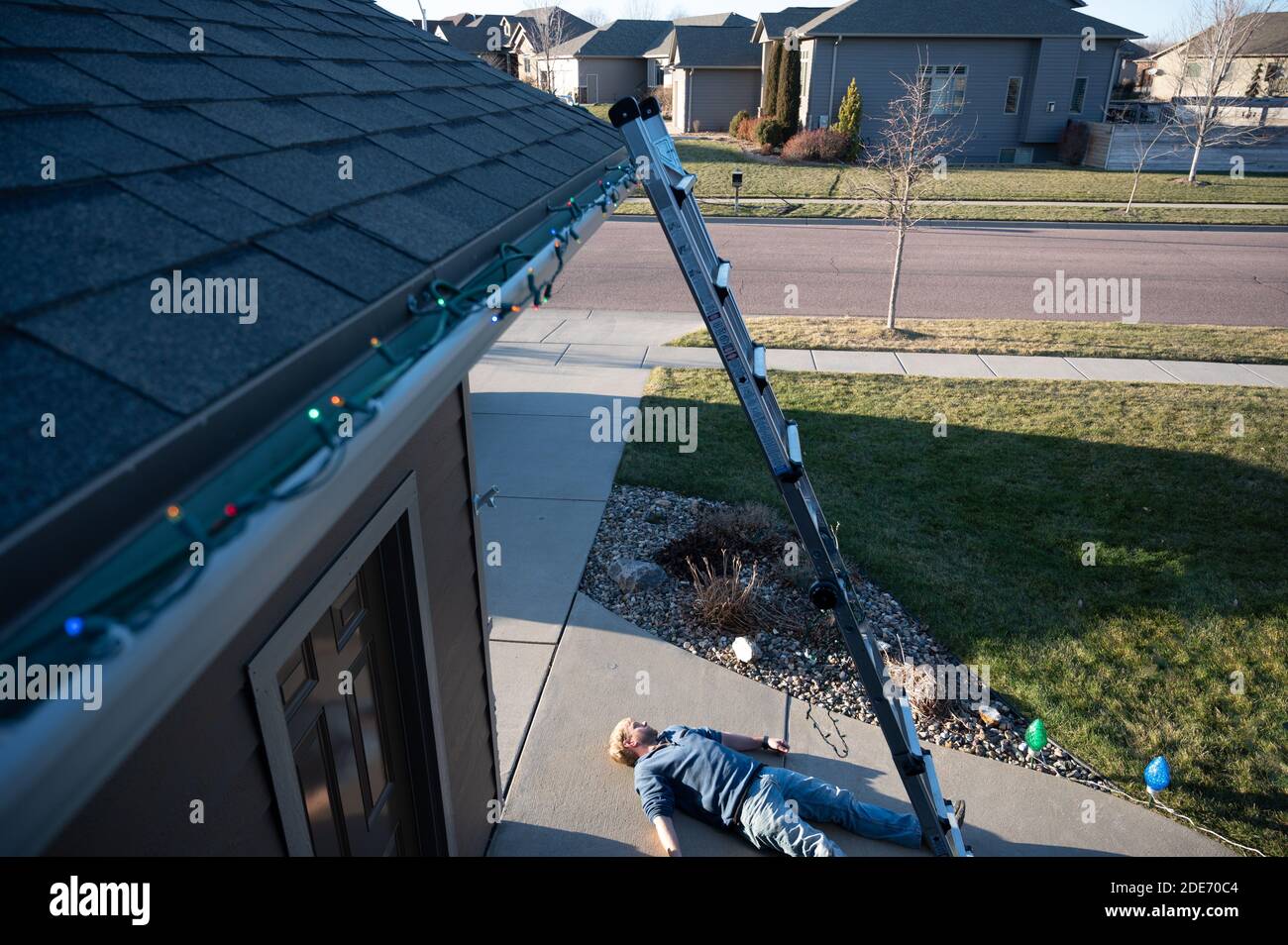 Concept of falling danger involved with hanging Christmas lights on the