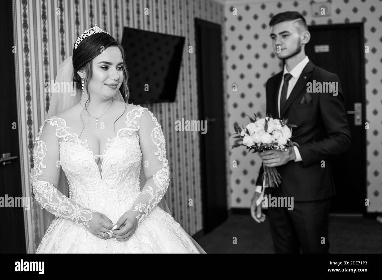 the groom meets the bride and gives a bouquet of flowers in the hotel room Stock Photo Alamy