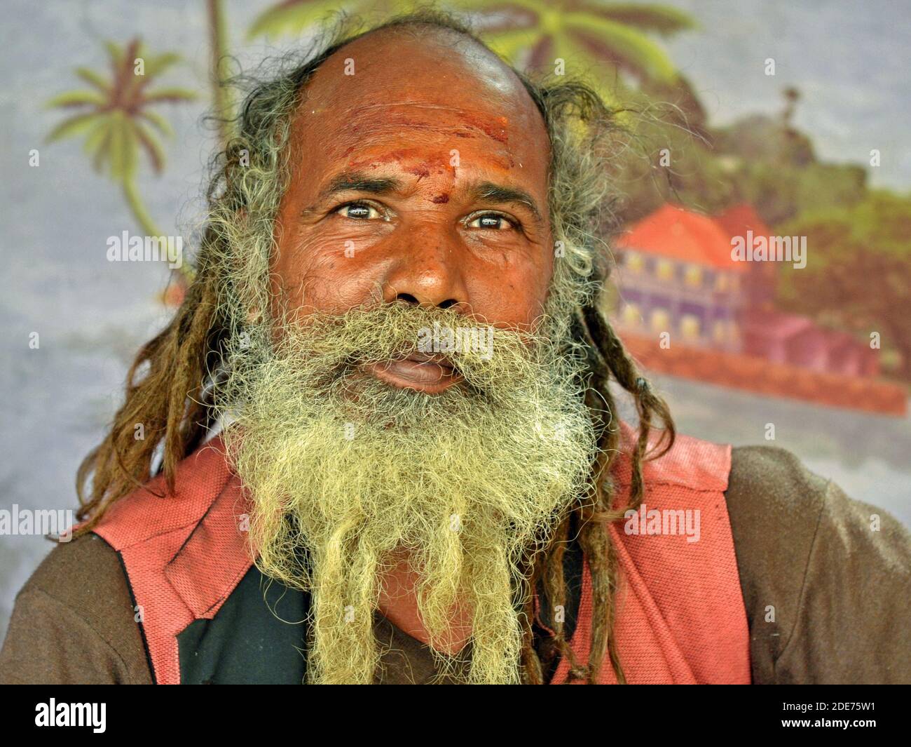 Elderly Indian Hindu Shaivite sadhu with rasta-style dreadlocks and beard poses for the camera during the Shivratri Mela (Bhavnath Fair). Stock Photo